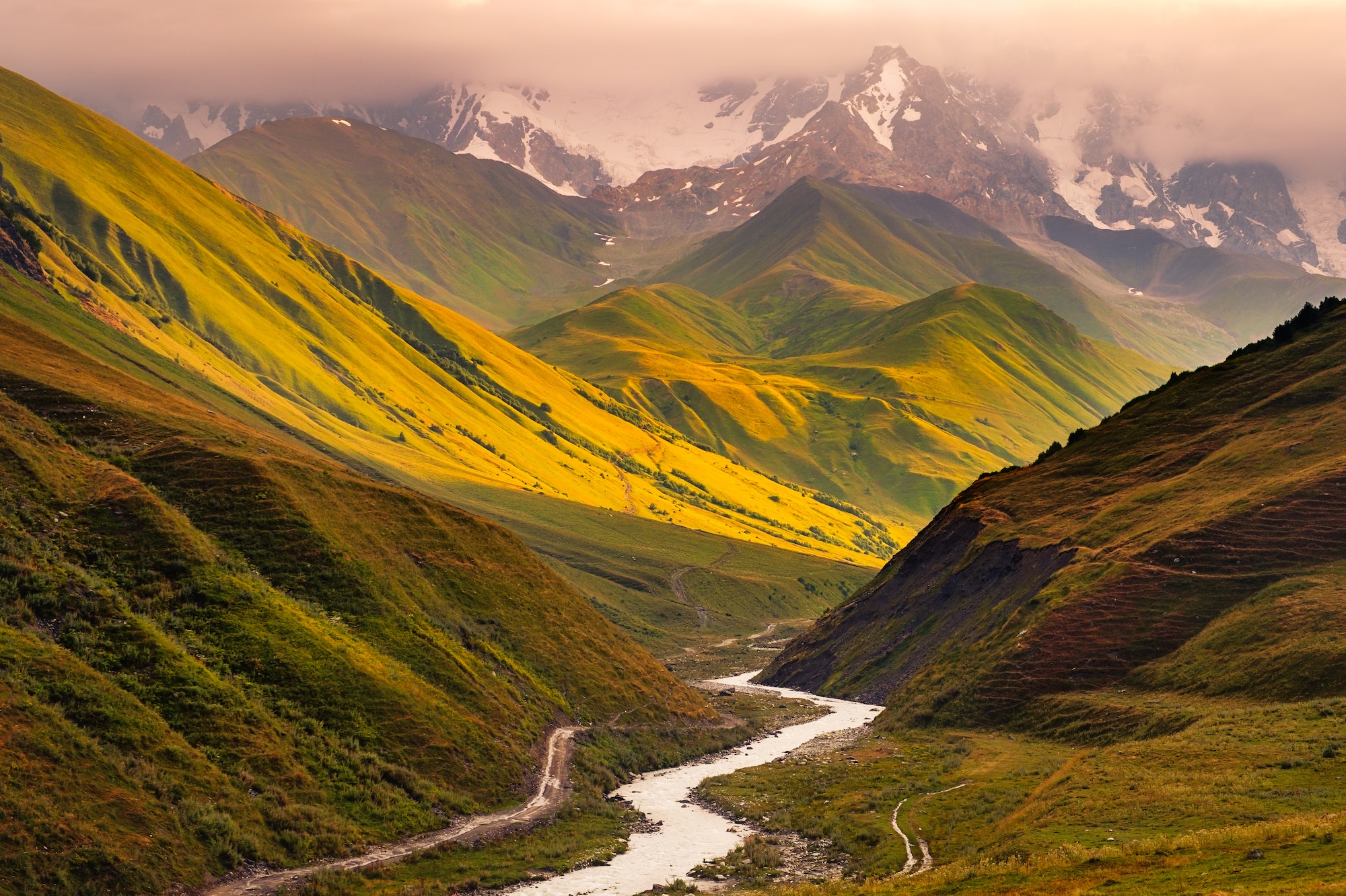 Beautiful sunrise with mountains, river and meadows in Ushguli, Georgia